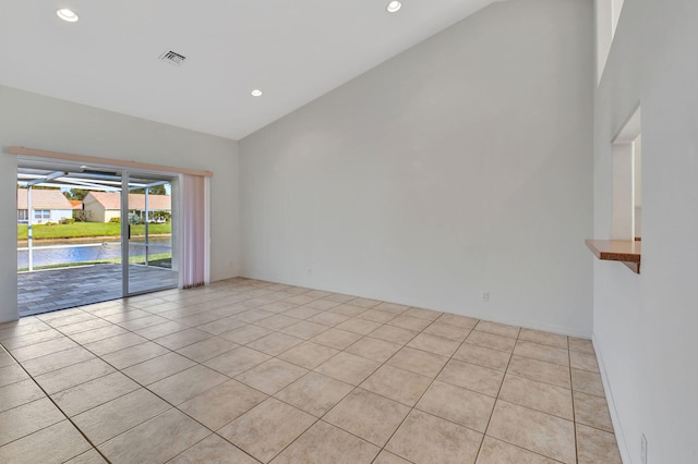 unfurnished room featuring high vaulted ceiling and light tile patterned flooring