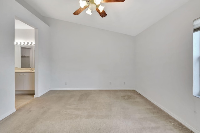 carpeted spare room with ceiling fan, sink, and vaulted ceiling