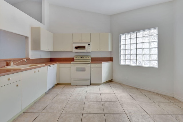 kitchen featuring light tile patterned flooring, white appliances, high vaulted ceiling, and sink