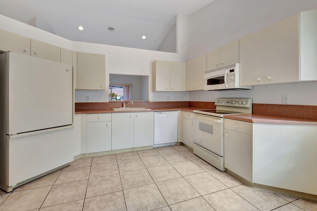 kitchen featuring light tile patterned floors, white appliances, high vaulted ceiling, and sink