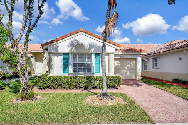 mediterranean / spanish-style home featuring a front yard and a garage