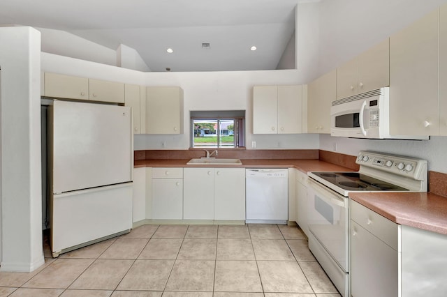 kitchen with cream cabinetry, white appliances, high vaulted ceiling, and light tile patterned flooring