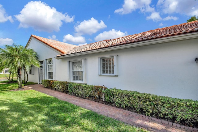 view of property exterior with a lawn