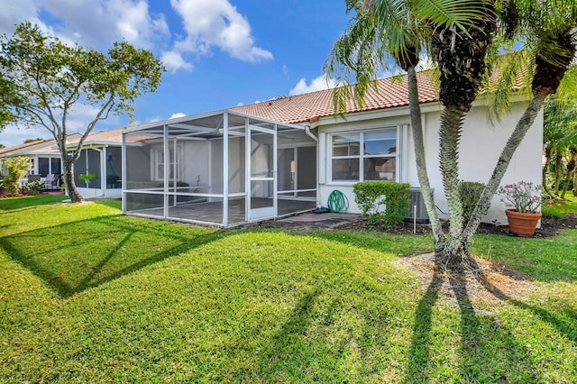 rear view of house featuring a lanai, a yard, and cooling unit