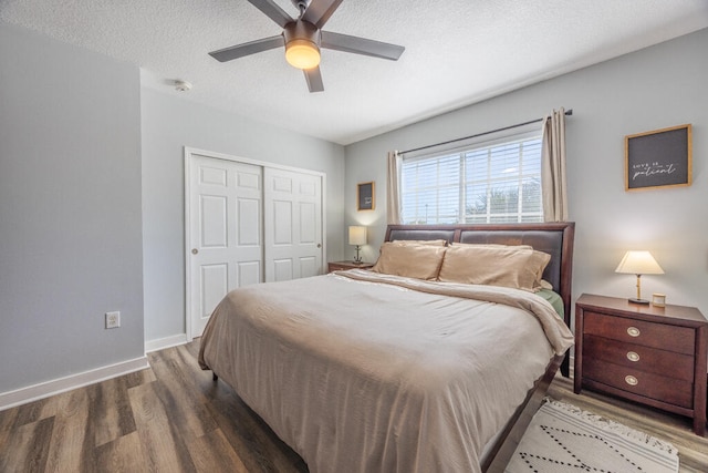 bedroom with ceiling fan, a closet, hardwood / wood-style floors, and a textured ceiling