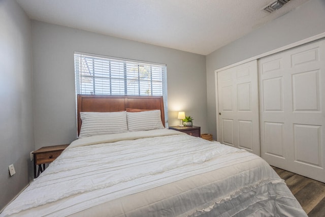 bedroom with dark hardwood / wood-style floors and a closet