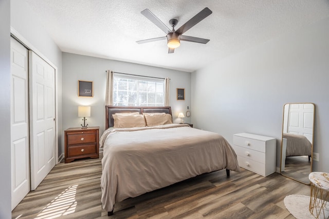 bedroom with hardwood / wood-style floors, ceiling fan, a textured ceiling, and a closet