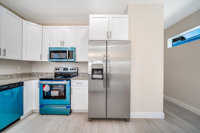 kitchen featuring white cabinets, light stone countertops, and appliances with stainless steel finishes