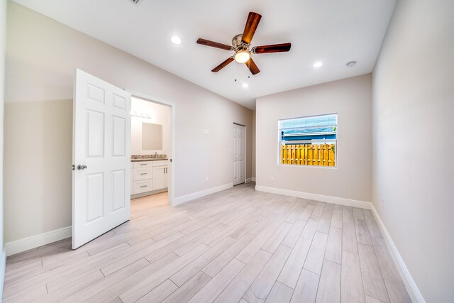 unfurnished bedroom featuring light hardwood / wood-style floors, ensuite bath, and ceiling fan