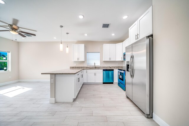 kitchen featuring stainless steel appliances, light stone counters, light hardwood / wood-style floors, decorative light fixtures, and white cabinets