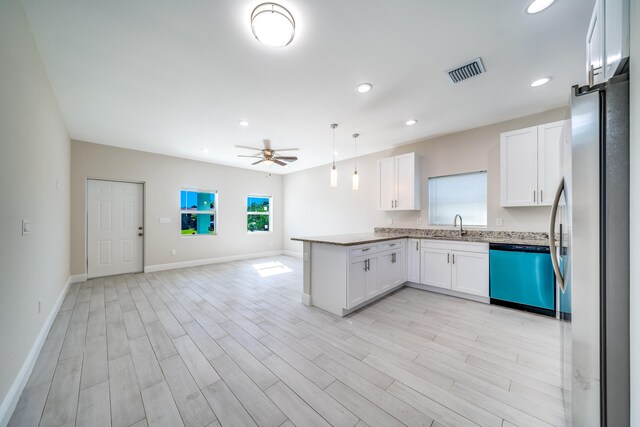 kitchen with a wealth of natural light, white cabinets, stainless steel appliances, and decorative light fixtures