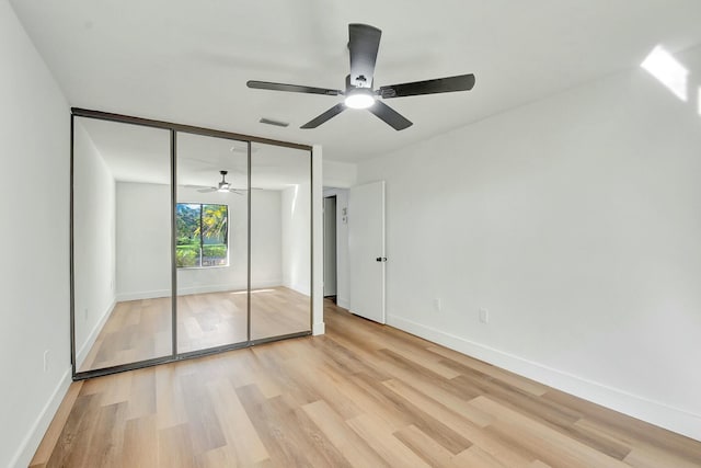 unfurnished bedroom with light hardwood / wood-style floors, a closet, and ceiling fan