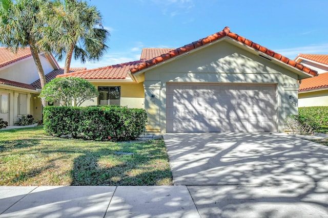 mediterranean / spanish house featuring a garage and a front lawn