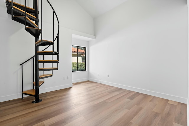 unfurnished room featuring high vaulted ceiling and light wood-type flooring