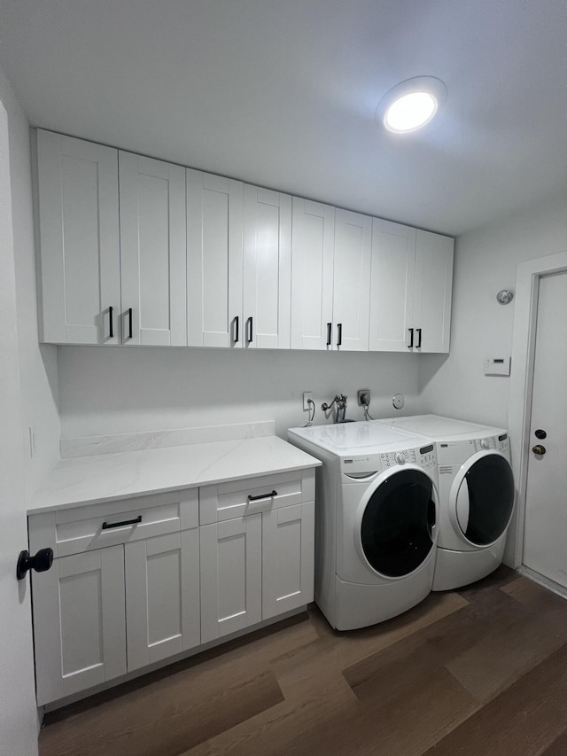 laundry area with cabinets, separate washer and dryer, and dark hardwood / wood-style floors