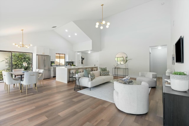 living room with hardwood / wood-style flooring, lofted ceiling, and a notable chandelier