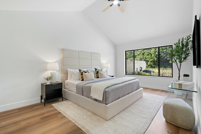 bedroom featuring hardwood / wood-style floors, high vaulted ceiling, and ceiling fan