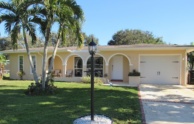 view of front of property featuring covered porch, a front yard, and a garage