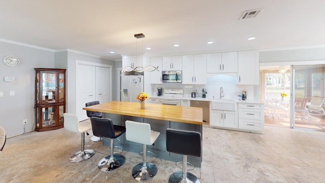 kitchen with white appliances, wooden counters, sink, crown molding, and white cabinetry