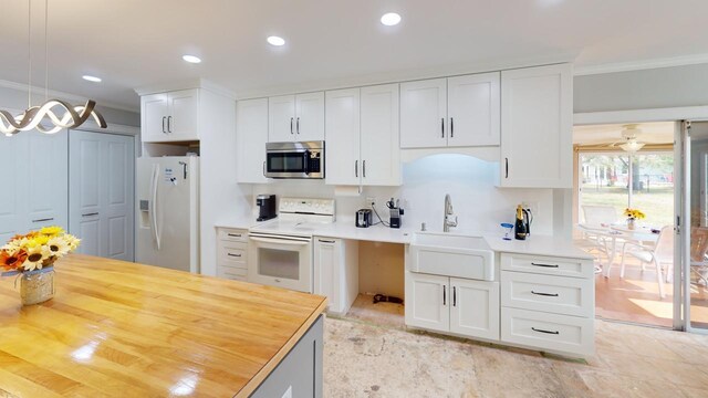 kitchen with decorative light fixtures, white cabinetry, white appliances, and sink