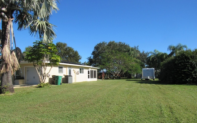 view of yard featuring cooling unit and a garage