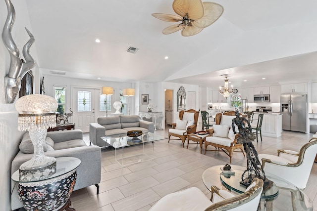 tiled living room featuring ceiling fan with notable chandelier and lofted ceiling