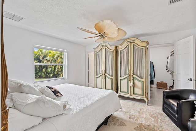 bedroom featuring ceiling fan and a textured ceiling