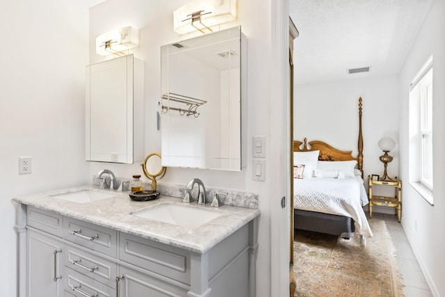 bathroom featuring tile patterned floors, plenty of natural light, a textured ceiling, and vanity