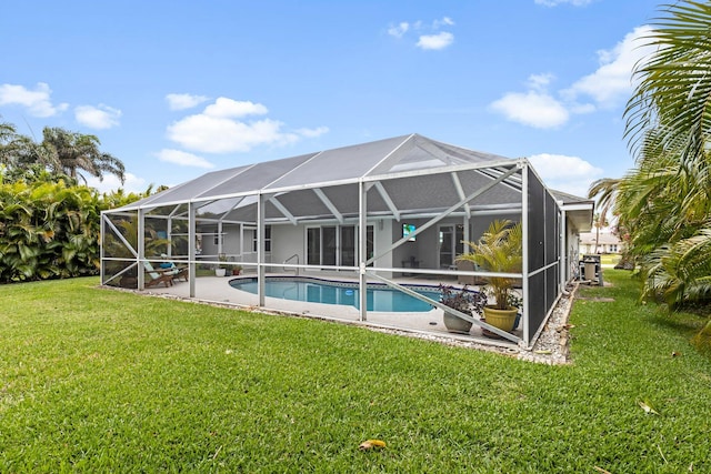 rear view of property featuring a lawn and glass enclosure