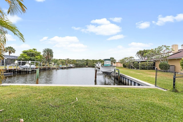 view of dock with a yard and a water view