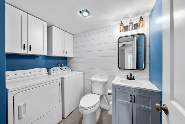 bathroom featuring washing machine and dryer, vanity, and toilet