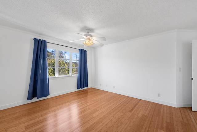 empty room featuring ceiling fan, ornamental molding, hardwood / wood-style floors, and a textured ceiling