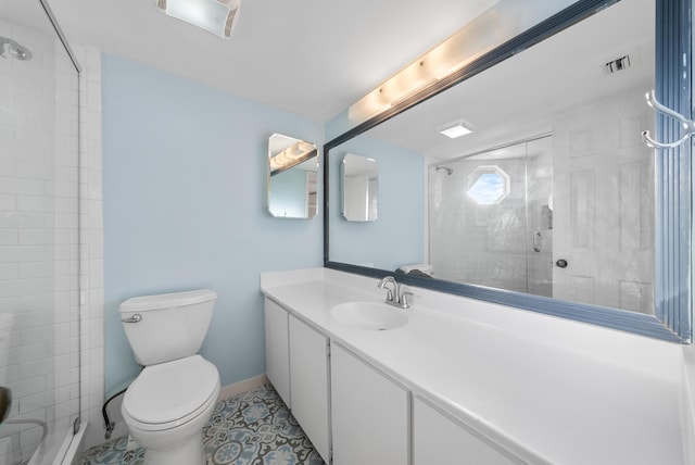 bathroom with vanity, a shower with shower door, tile patterned floors, and toilet