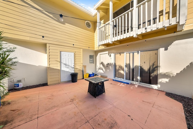 view of patio featuring a balcony and a fire pit