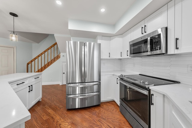 kitchen with stainless steel appliances, light stone countertops, white cabinets, and dark hardwood / wood-style flooring