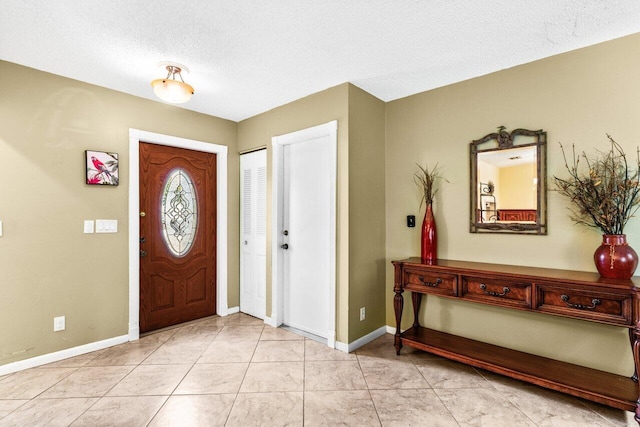 entryway featuring light tile patterned floors and a textured ceiling