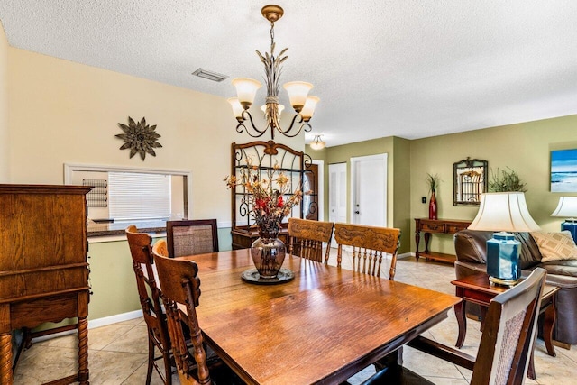 tiled dining area featuring a chandelier and a textured ceiling