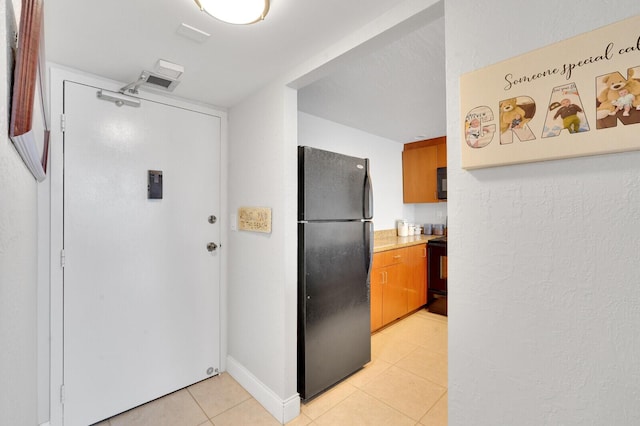 kitchen featuring light tile patterned flooring and black appliances