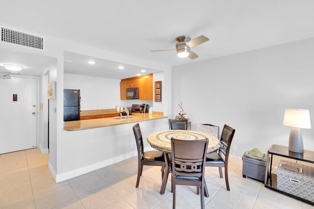 dining space with ceiling fan, sink, and light tile patterned floors