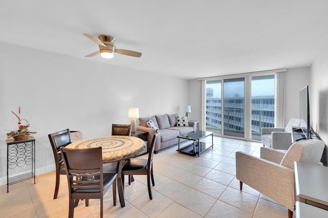 tiled dining area featuring expansive windows and ceiling fan