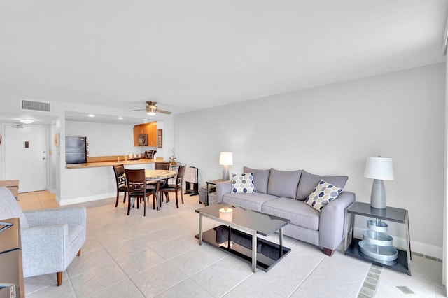 living room with ceiling fan and light tile patterned floors