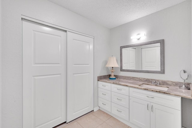 bathroom featuring vanity, a textured ceiling, and tile patterned floors