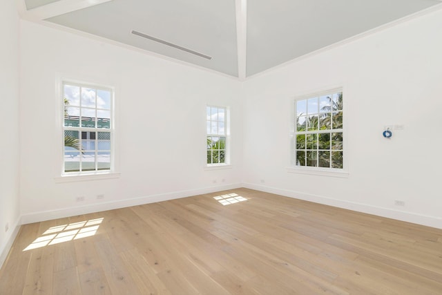 234 Miramar Way, West Palm Beach, FL 33405 - empty room with healthy amount of natural light, light wood-style flooring, baseboards, and vaulted ceiling