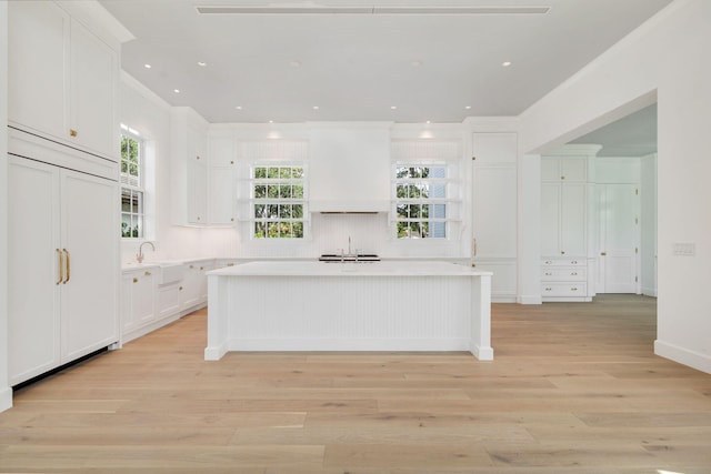 234 Miramar Way, West Palm Beach, FL 33405 - kitchen featuring open shelves, crown molding, light wood-type flooring, white cabinetry, and a center island