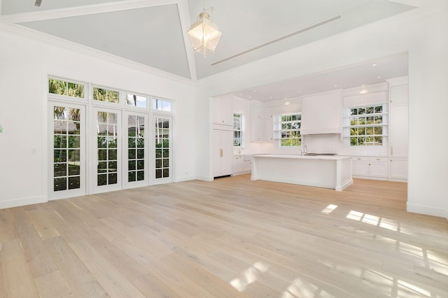 234 Miramar Way, West Palm Beach, FL 33405 - unfurnished living room featuring light wood finished floors, high vaulted ceiling, and baseboards