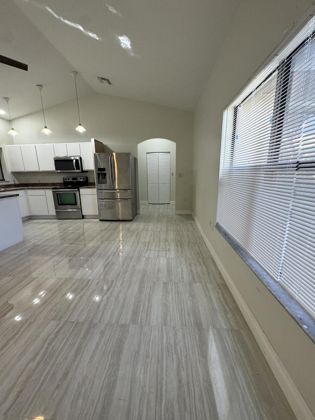 kitchen featuring light hardwood / wood-style flooring, vaulted ceiling, decorative light fixtures, white cabinetry, and stainless steel appliances