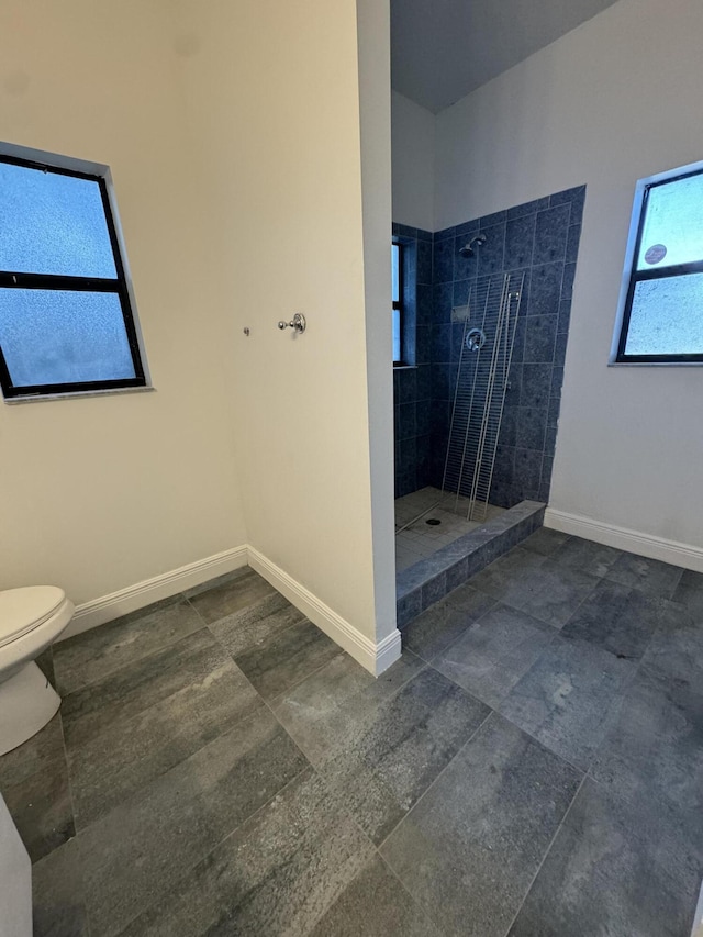 bathroom with a healthy amount of sunlight, tile walls, and toilet