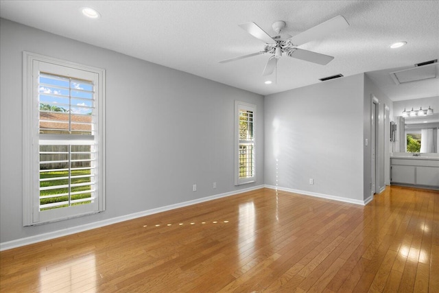 unfurnished room featuring hardwood / wood-style flooring, ceiling fan, and a textured ceiling