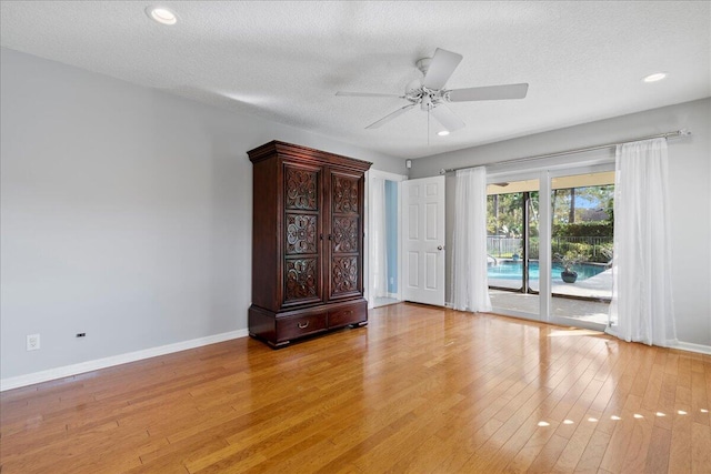 empty room featuring ceiling fan, light hardwood / wood-style floors, and a textured ceiling