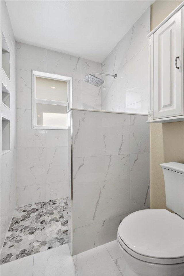 bathroom with toilet and a tile shower